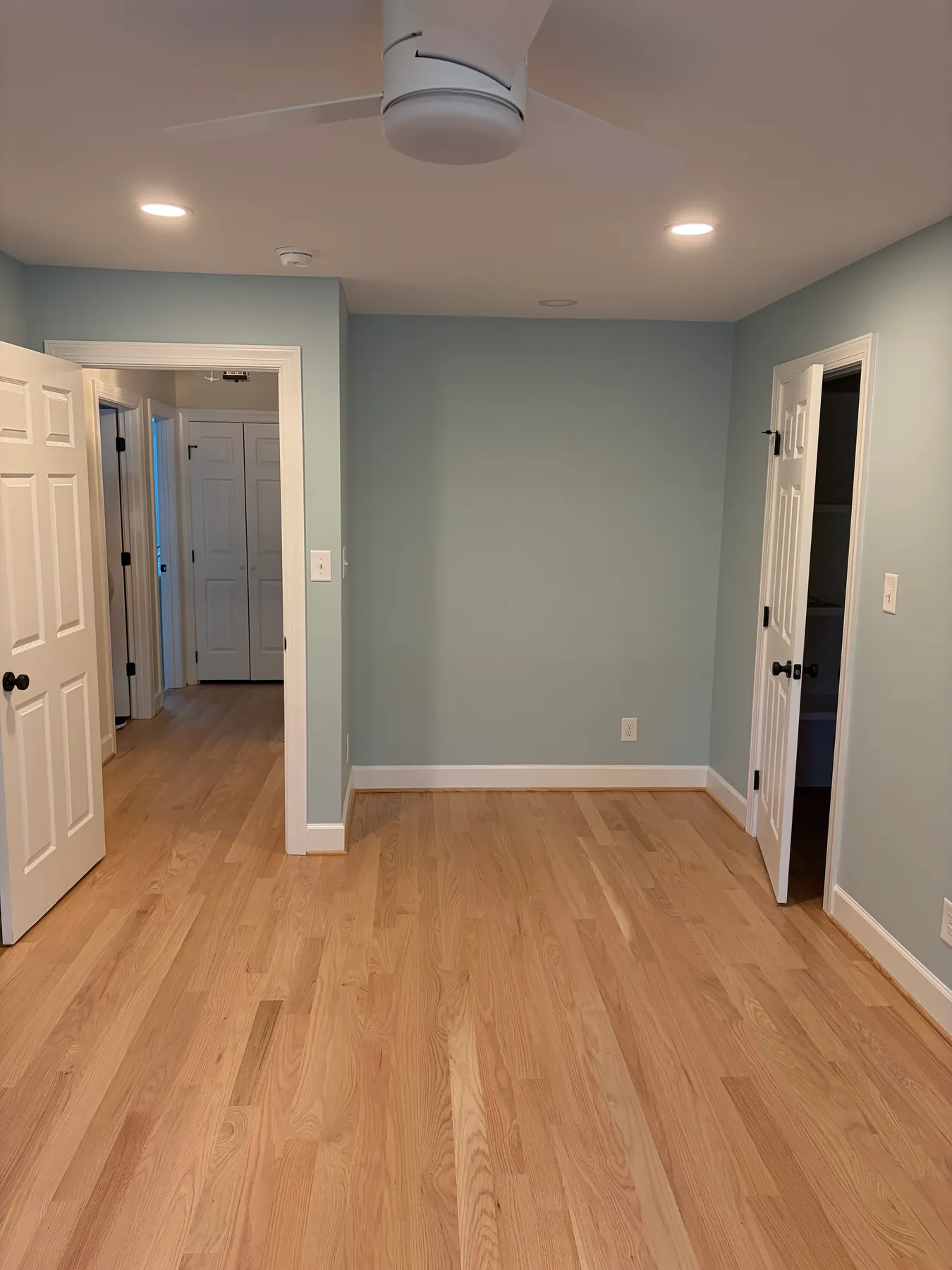 Finished Brown project room viewed toward an interior doorway with light wood flooring, ceiling fan, and recessed lights