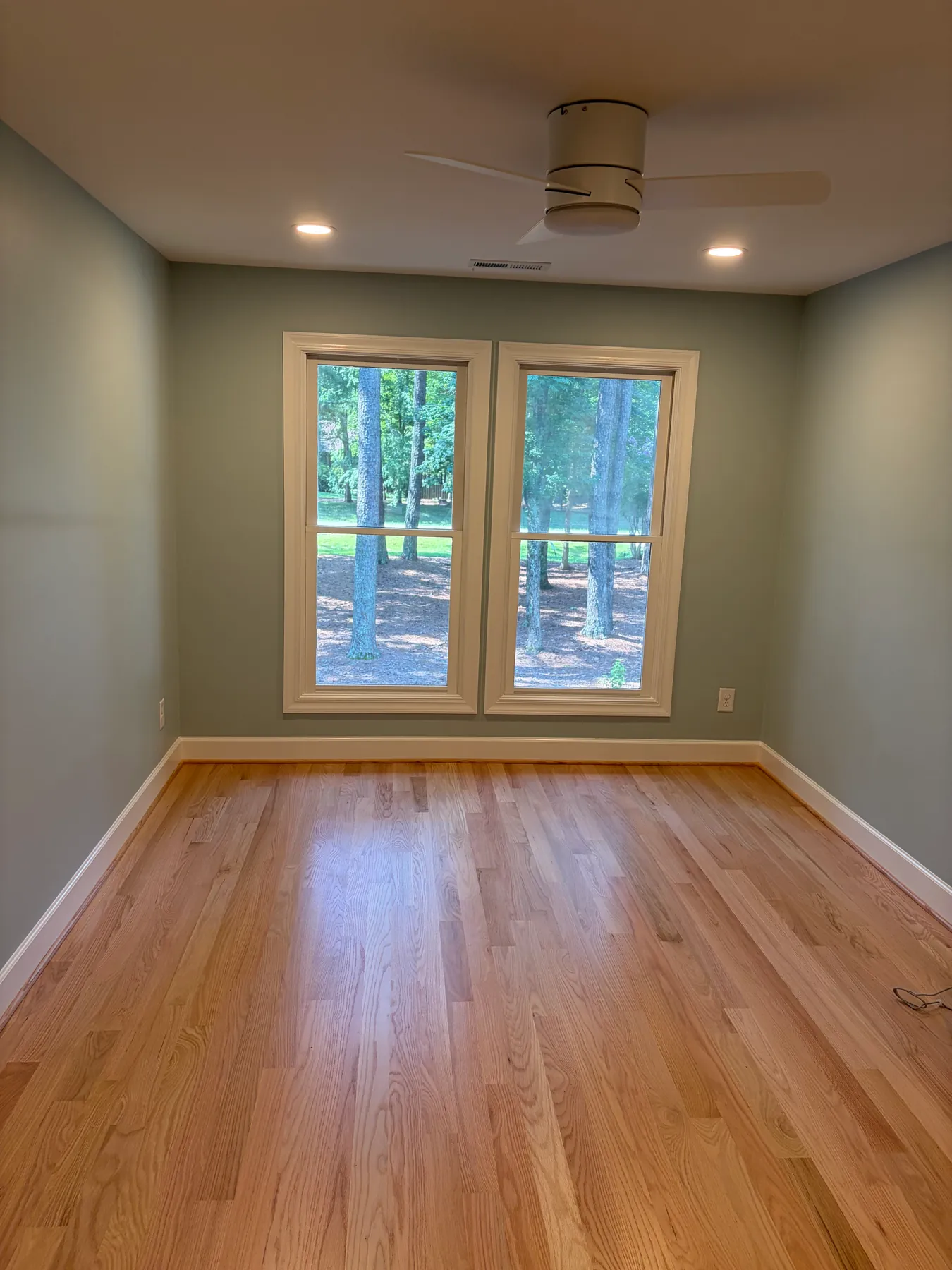 Finished Brown project room with light wood flooring, ceiling fan, recessed lights, and glass double doors