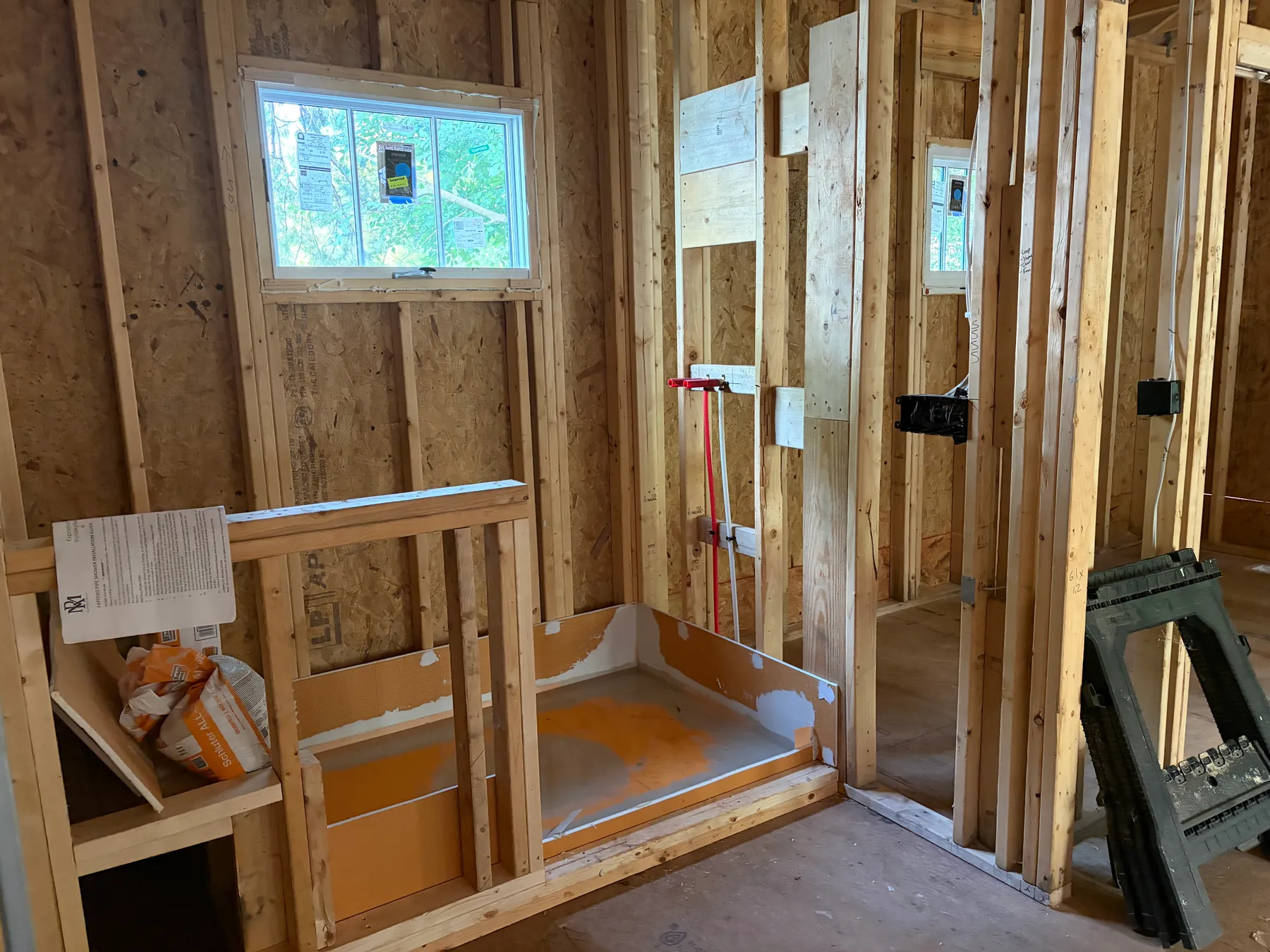 Interior wall framing with window openings and exposed electrical boxes in the Janet home addition